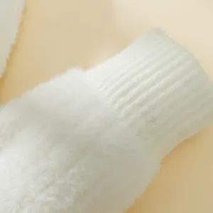 Primo piano dettagliato di guanti di peluche caldi invernali, morbida trama in tessuto spesso.