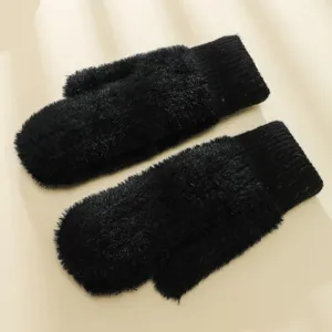 Primo piano delle morbide moffole invernali in peluche nero, con spessa trama soffice e polsini.