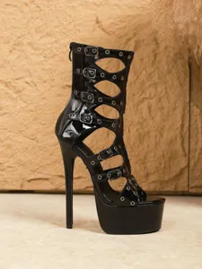 Close-up of black patent leather open-toe platform cutout high heel sandal boots with buckles.