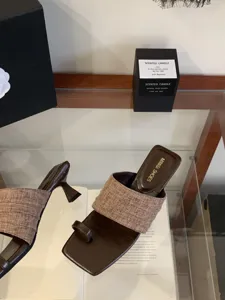 Primer plano de sandalias de tacón con puntera cuadrada y tira trenzada elegante.