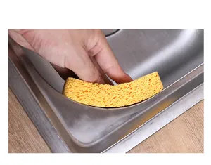 Nahaufnahme des gelben Holzzelluloseschwamms mit poröser Textur bei der Küchenreinigung.