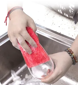 Red sponge dishwashing kitchen cleaning tool detail shot showing foaming and glass washing.