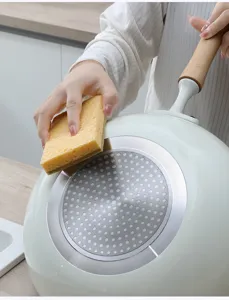Kitchen cleaning sponge detail shot, showing double-sided material wiping pan bottom easily.