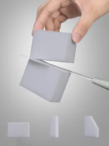 Primer plano detallado que muestra una esponja mágica gris cortada con un cuchillo.