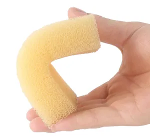 Flexible yellow porous kitchen cleaning sponge detail shot showcasing elasticity and texture.