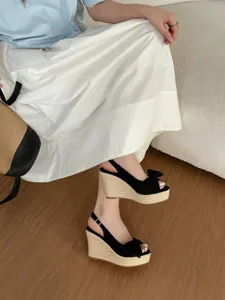 Sandali con zeppa nera in corda, dettaglio fiocco e suola plateau per un look quotidiano.