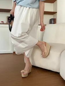 Vista dettagliata dei sandali con zeppa beige ed espadrillas con fiocco in stile casual.
