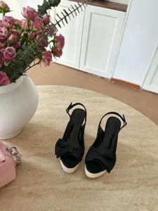 Eleganti sandali con zeppa nera in corda, plateau e fiocco raffinato per abbigliamento quotidiano.