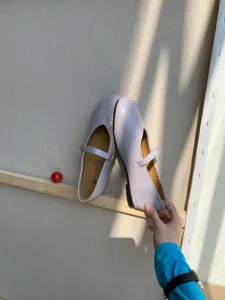 Nahaufnahme von helllila runden Damen Mary Jane Flachschuhen mit Riemen, stilvolle Präsentation.