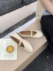 Detailaufnahme von beigen Mary Jane Halbschuhen mit Riemen und runder Kappe im Stil.