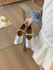 Silberne Metallic Mary Jane Ballerinas Detailansicht mit runder Kappe und feinem Riemen.