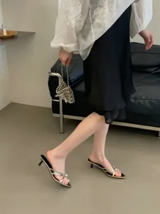 Schicke spitze Pantoletten mit Pfennigabsatz, schmalen Riemen und Metallringen für Damen.