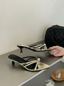 Detailansicht französischer Retro metallischer Kitten-Heel-Pantoletten mit Perlendekor.