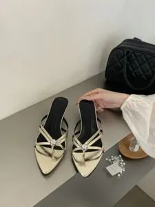 Detailansicht französischer Retro-Mules in Gold mit spitzer Form und schmalem Absatz.