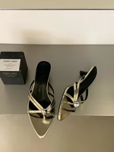 Detailansicht golden metallische spitze Zehe Riemchen niedriger Stilettos Mules mit Metallkugel.