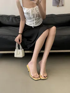 Detail view of stylish transparent high heel mules, clear strap design, summer footwear.