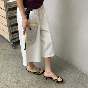 Sandalias de tacón sensato para mujer en ante negro con detalles de tachuelas doradas.