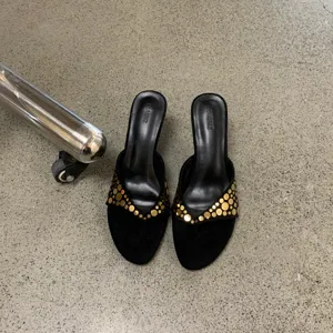 Sandalias de tacón de aguja tipo tanga retro en ante para mujer con tachuelas doradas.