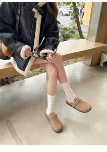 Bequeme braune Pantoletten mit Fellfutter und Schnalle im Detail, kuschelige Winterschuhe.