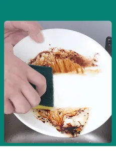 Detail view of kitchen cleaning sponge cleaning dirty plate, high water absorption efficiency.