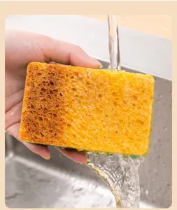 Wood pulp sponge detail showing porous texture and water absorption under running tap water.