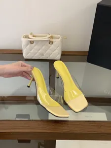 Detailed view of fashionable transparent high heel mules sandals with yellow pointed toe for women.