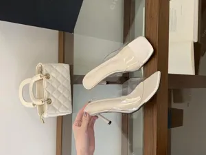 Detailed view of fashionable transparent high-heeled mules with chic pointed toe design.