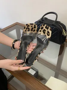 Detailed view of women fashion leopard print transparent high heel mule sandals with thin stiletto.