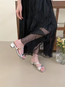Gros plan de sandales élégantes à talons bloc argentés avec détail de boucle en métal chic.