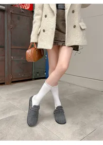 Detailansicht grauer Filz-Clogs, bequeme Schlupfschuhe mit kuscheligem Futter und Schnalle.