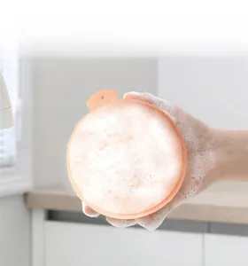 Nahaufnahme eines runden Reinigungsschwamms mit reichlich Schaum für die Küchenreinigung.