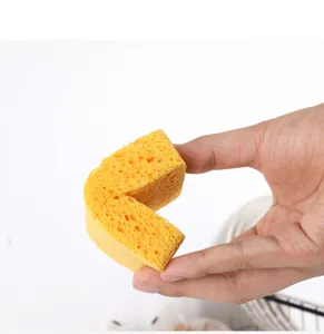 Detailansicht des gelben Holzzellstoff-Reinigungsschwamms mit poröser Textur und biegsamer Ecke.