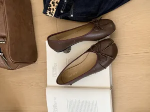 Brown split-toe ballet flats detailed view, elegant bow accent and soft leather upper style.