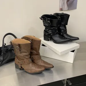 Vue détaillée de bottes western vintage à bout pointu, talons épais et boucles métalliques.