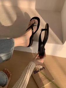 Minimalist black thong sandals for women, chic flat flip flops with silver ball decor.
