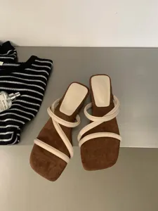 Λεπτομερής όψη καφέ σουέτ flat σανδαλιών με τετραγωνισμένη μύτη και λουράκια.