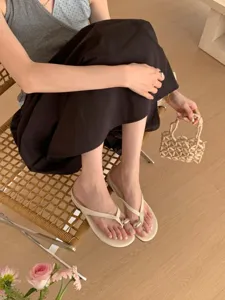Close-up shot of minimalist women's thong sandals featuring stylish metal bead decor, soft sole.