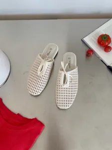Detalle en primer plano de zapatos mules de punta cuadrada tejidos en color crema chic.