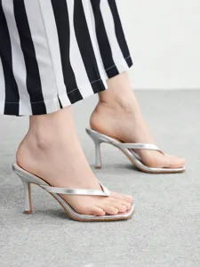 Elegant silver stiletto thong sandals detail, featuring comfortable square toe and shiny finish.