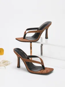 Detail shot of brown patent leather thong high heels, elegant square toe design.