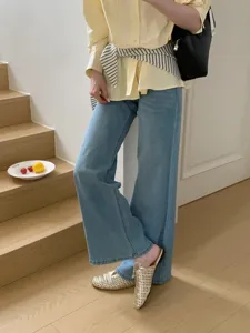 Vista detallada de elegantes mules doradas trenzadas con punta cuadrada para un look chic.