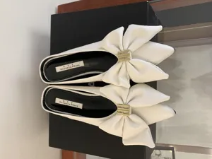 Elegante witte muiltjes met puntneus, grote lederen strik en metalen gesp voor dames zomermode