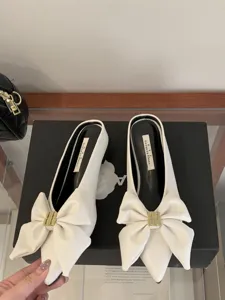 Witte muiltjes met puntige neus, strik en metalen gesp, chique platte sandalen in Franse stijl.