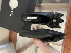 Stijlvolle zwarte muiltjes met grote strik en metalen gesp, comfortabele platte schoenen.