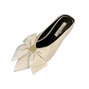 Witte puntige mules schoenen detail met elegante strik en luxe gouden metalen gesp ontwerpen.
