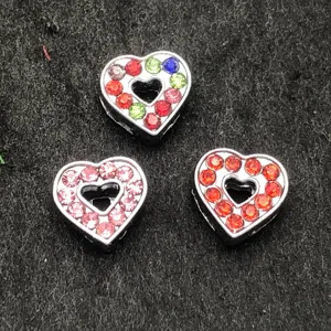 Primo piano di ciondoli fai-da-te in metallo a forma di cuore da 8 mm con strass colorati.