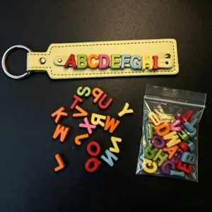 Detailansicht von bunten DIY Kunststoff Buchstaben Perlen Schlüsselanhänger und Zubehörteile.