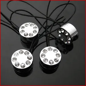 Vue détaillée du charm pendentif pour téléphone cylindrique en strass argenté avec cordon.