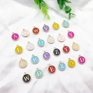 Vue détaillée de charms alphabet émaillés colorés, pendentifs ronds en alliage pour bijoux.