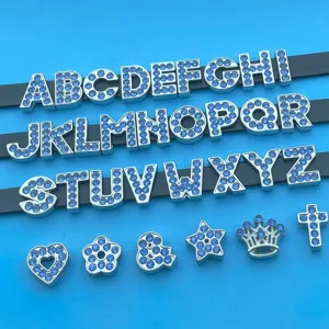Gros plan sur les charms lettres en strass bleu de 8mm et symboles pour bijoux DIY.